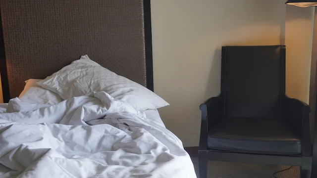 Un lit et une couverture sans une chambre l'hôtel. Source : iStock
